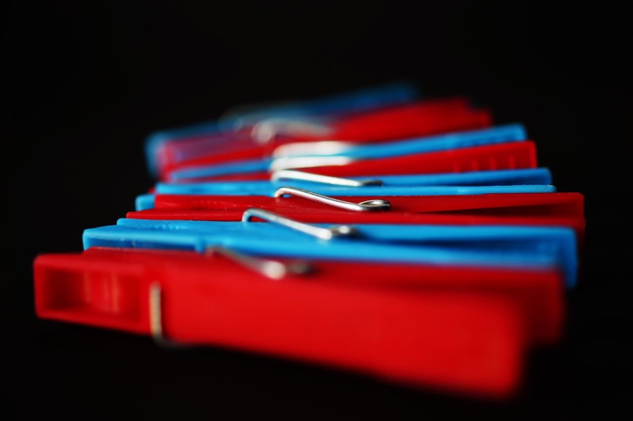 Colorful clothespins arranged in a vibrant pattern on a dark background.